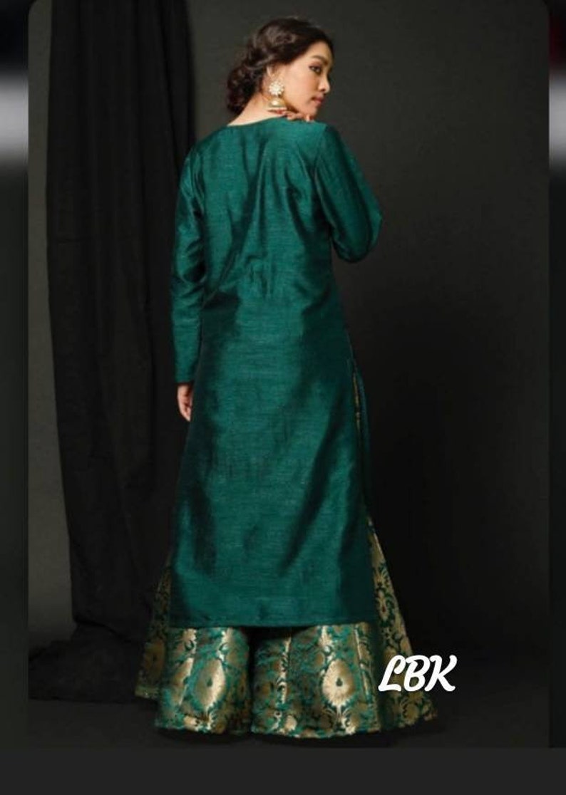 Op de afbeelding: Een lange, tealgroene kurta met lange mouwen en een bijpassende tealgroene palazzo broek met een gouden brokaatpatroon. De palazzo broek heeft een uitlopende silhouet. De outfit is in traditionele Indiase stijl.