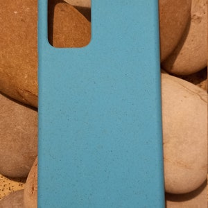 A turquoise case sitting on pebbles