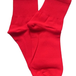 May include: A pair of red ankle socks. The socks are made of a soft, comfortable material and have a ribbed texture.