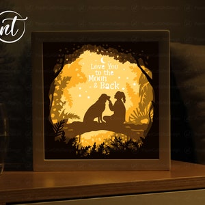 Könnte beinhalten: Eine 3D-Schattenbox aus Papier mit einer Silhouette eines Mädchens und eines Hundes, die auf einem Ast in einem Wald sitzen. Der Text "Love You to the Moon & Back" steht in der Mitte des Bildes.