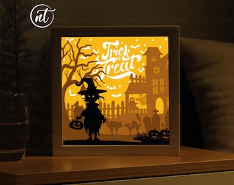May include: A light-up Halloween scene with a witch holding a pumpkin, a haunted house, and the text "Trick or Treat".