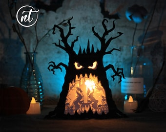 May include: A black papercraft Halloween tree with a scary face and a glowing interior. The tree is lit from within, creating a spooky and festive atmosphere.
