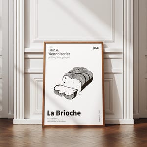 Peut inclure: Une affiche encadrée avec une illustration en noir et blanc d'une brioche et d'une tranche coupée. L'affiche est intitulée "Pain & Viennoiseries" et "La Brioche". L'œuvre est présentée contre un mur blanc, avec un sol en bois.