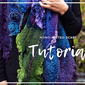 Könnte beinhalten: Ein farbenfroher Nuno-Filz-Schal in Lila, Blau und Grün. Der Schal hat ein strukturiertes Design mit floralen Verzierungen und dem Wort "Tutorial" in weißer Schrift. Der Schal wird vor einem verschwommenen Hintergrund gezeigt.