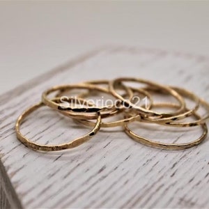 Può includere: Un set di sei anelli impilabili in oro martellato. Gli anelli sono sottili e delicati e sono perfetti per essere sovrapposti.