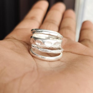 K&ouml;nnte beinhalten: Ein silberner Ring mit geh&auml;mmerter Textur. Der Ring besteht aus vier &uuml;bereinander gestapelten B&auml;ndern.