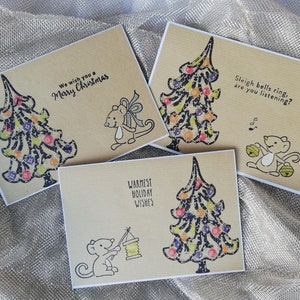 Cartoline di Natale a colori naturali. Cartolina dell'albero di Natale. Topo e un albero di Natale. Sentimenti disponibili in tre lingue diverse.