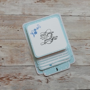 Carte de chute d’eau faite à la main. Carte interactive. Fond bleu clair avec des points blancs. Carrés blancs avec des sentiments et des fleurs différents.