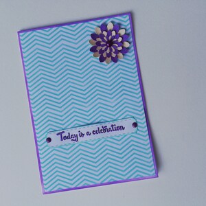 Tarjeta de felicitación hecha a mano. Hoy es una celebración. Fondo púrpura y verde claro. Flor de papel amarillo y púrpura. Sobre incluido