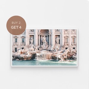 Könnte beinhalten: Ein Foto des Trevi-Brunnens in Rom, Italien. Der Brunnen ist aus weißem Marmor und zeigt Skulpturen von mythologischen Figuren. Das Wasser fließt aus dem Brunnen in einen Pool darunter.