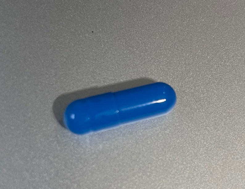 May include: A single blue capsule pill.