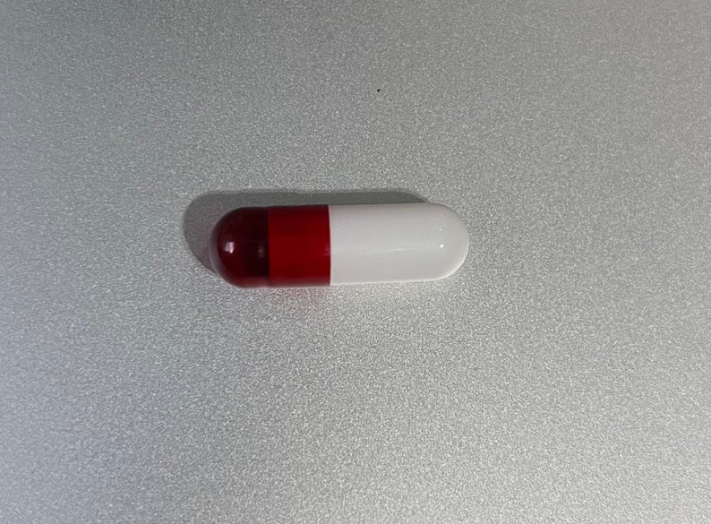 May include: A red and white capsule pill.