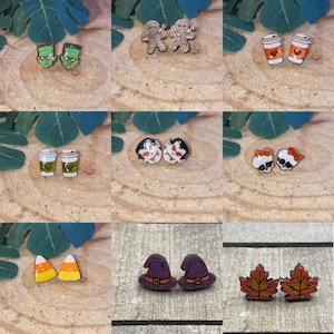 May include: A set of 10 pairs of Halloween-themed earrings. The earrings are made of wood and feature various designs, including candy corn, witches hats, coffee cups, and skeletons.