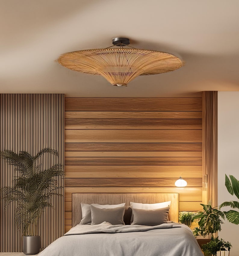 Pode incluir: Um quarto com uma parede de madeira e uma lumin&aacute;ria de teto tecida. A cama tem uma cabeceira cinza e um edredom cinza. H&aacute; plantas no quarto.