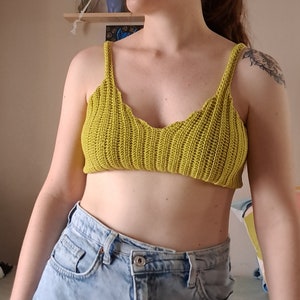 Może przedstawiać: Krótki top w kolorze limonkowym wykonany na szydełku z falbanką przy dekolcie.
