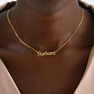 Op de afbeelding: Een gouden ketting met een naamhanger met de tekst "Barbara".