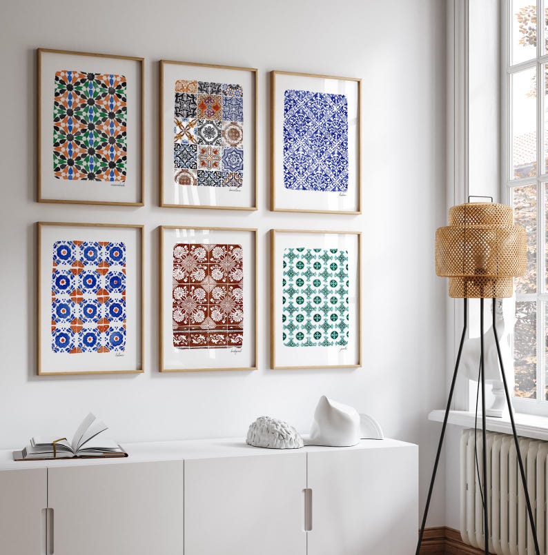 May include: A set of six framed wall art prints featuring various geometric and floral tile patterns in blue, green, orange, and brown tones. Each rectangular print is encased in a light wood frame and arranged in two rows of three on a white wall.