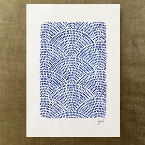 May include: A rectangular white art print featuring a repeating pattern of blue fan-shaped motifs composed of small dots. The design is arranged in a grid-like structure across the center of the paper. The word kyoto is written in cursive in the bottom right corner.