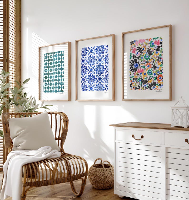 May include: Three framed rectangular wall art prints displayed in a row. The left print features a teal geometric tile pattern. The center print displays a blue and white floral tile design. The right print shows a colorful abstract floral pattern.
