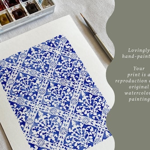 May include: A white sheet of paper featuring a blue watercolor painting with a repeating diamond and floral pattern. A paintbrush and a watercolor paint set are visible. The text reads: Lovingly hand-painted. Your print is a reproduction of my original watercolour painting.