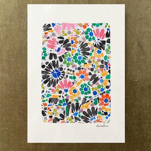 May include: A rectangular art print on white paper featuring a colorful mosaic pattern of geometric shapes in black, pink, green, orange, blue, and yellow. The design is composed of various angular segments and the word barcelona is written in script.