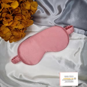 May include: A pink satin sleep mask with an elastic band. The mask is made of 100% silk and is certified by OEKO-TEX STANDARD 100. The certification means that the product has been tested for harmful substances.