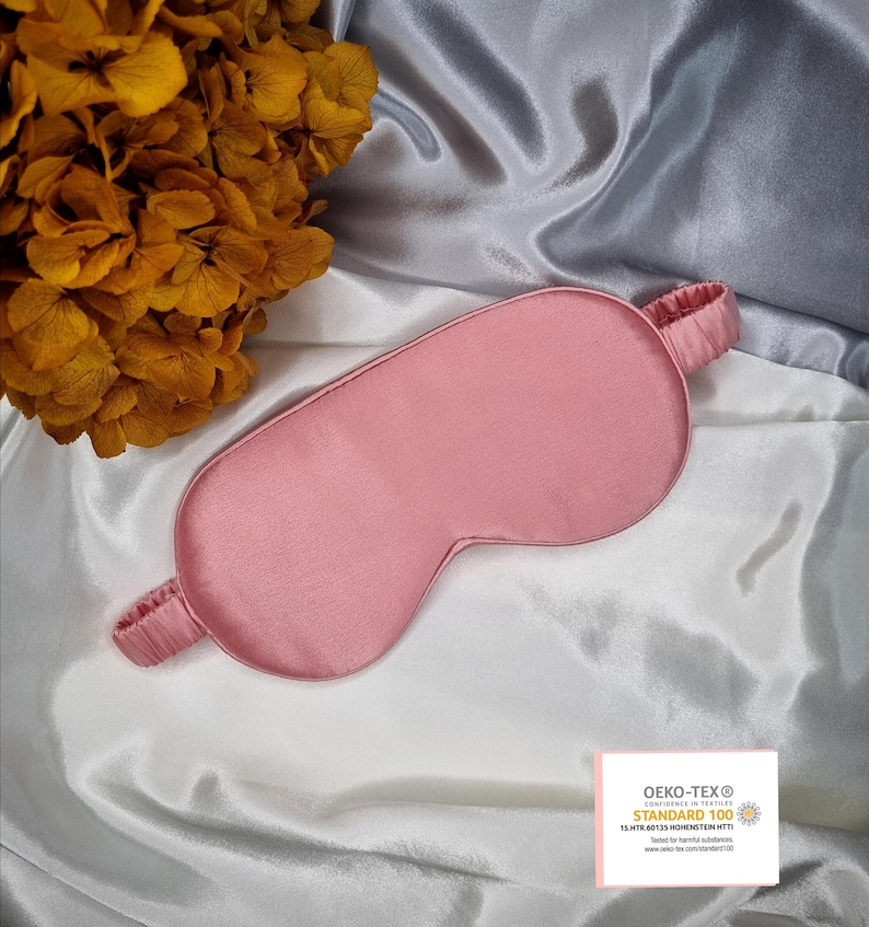 May include: A pink satin sleep mask with an elastic band. The mask is made of 100% silk and is certified by OEKO-TEX STANDARD 100. The certification means that the product has been tested for harmful substances.