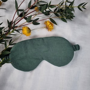 Puede incluir: Una m&aacute;scara para dormir de color verde oscuro hecha de tela de lino. La m&aacute;scara tiene un dise&ntilde;o simple y es perfecta para bloquear la luz.