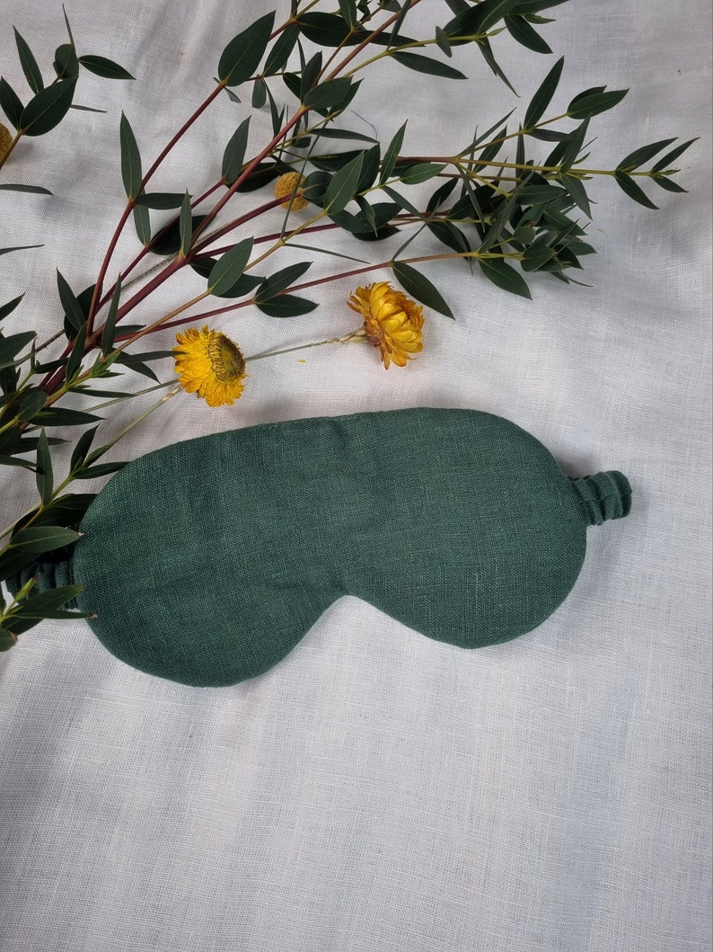 Puede incluir: Una m&aacute;scara para dormir de color verde oscuro hecha de tela de lino. La m&aacute;scara tiene un dise&ntilde;o simple y es perfecta para bloquear la luz.