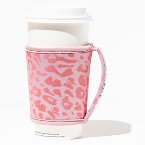May include: Pink leopard print coffee cup holder with a handle. The holder is made of neoprene and is designed to keep your drink hot or cold.