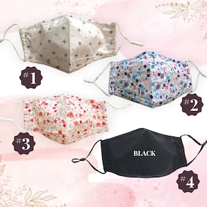 May include: Four different face masks. One is white with a small cross pattern, one is white with a small floral pattern, one is white with a larger floral pattern, and one is black with the word "BLACK" printed on it.
