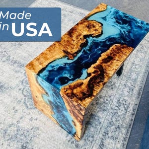 May include: A wooden coffee table with a blue and black epoxy resin river design. The table is made in the USA.