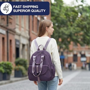 May include: A purple backpack with light purple straps and accents. The backpack has multiple pockets and a top handle. The image includes the text "FAST SHIPPING SUPERIOR QUALITY" in a blue rectangle.