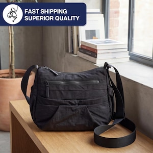 May include: Black crossbody bag with multiple zippered compartments and an adjustable shoulder strap. The bag is made of a textured material and has a sleek, minimalist design. The text "FAST SHIPPING SUPERIOR QUALITY" is in the upper left corner.