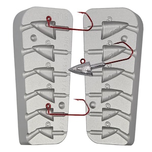 Puede incluir: Un molde de metal gris de dos piezas para fundir señuelos de pesca. El molde tiene ocho cavidades para fundir señuelos. El molde está etiquetado como "F108" y "VMC 5150 3/0 2/0". Un anzuelo de pesca rojo está unido al molde.