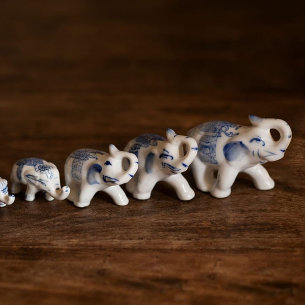 Une famille de 5 figurines blanches et bleues d’éléphants de porcelaine