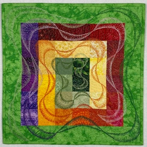 May include: A green, red, yellow, purple, and orange quilt with a swirling pattern. The quilt is made of fabric squares sewn together to create a larger design.