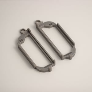 May include: Two gray, rectangular frames with rounded corners and a small loop at the top. The frames have a hollow center and are made of a solid, matte material. The frames are designed to hold something.