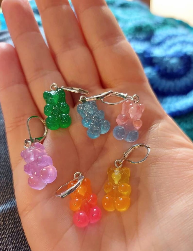 Puede incluir: Seis pendientes con forma de osito de goma en varios colores, incluyendo verde, azul, rosa, naranja y rojo. Los pendientes est&aacute;n unidos a ganchos de pendientes plateados.