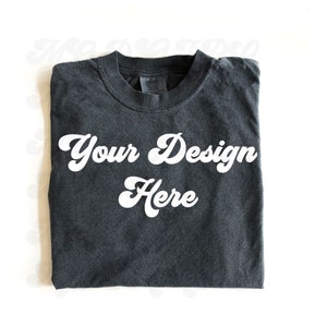 May include: A dark gray t-shirt with the text "Your Design Here" in a white retro font.