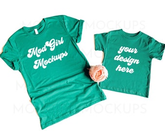 May include: Two teal green t-shirts, one adult size and one child size, with white text. The adult shirt says "Mod Girl Mockups" and the child shirt says "your design here".