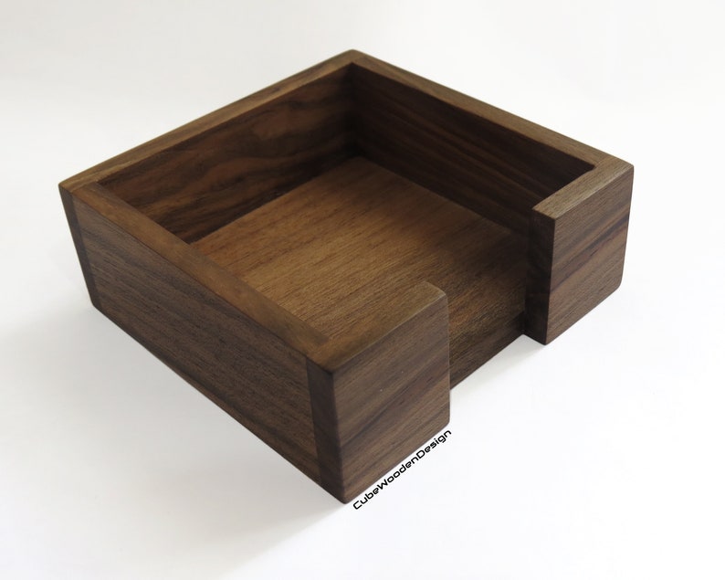 K&ouml;nnte beinhalten: Ein quadratischer Holz-Tischtuchhalter aus dunklem Walnussholz. Die Box hat eine einzelne &Ouml;ffnung an einer Seite f&uuml;r einfachen Zugang zu den Taschent&uuml;chern.