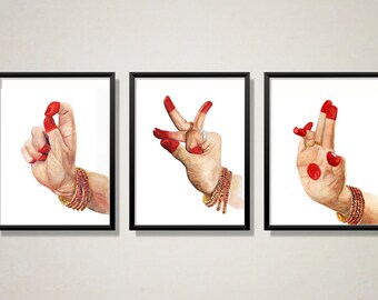 May include: Three framed watercolor paintings of hands in different mudras, a traditional Indian hand gesture used in dance and ritual. The hands are painted in a realistic style with red nail polish and intricate details.