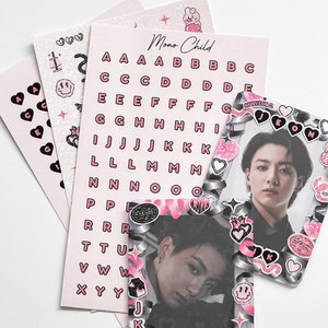 May include: A collection of pink and black stickers and photo cards. The stickers include hearts, letters, and other graphics. The photo cards feature a person in decorative frames. The text "Mono Child" is visible.