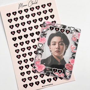 May include: A pink card with black heart-shaped letter stickers and a clear photo frame. The frame has decorative stickers and a photo of a person. The card has the text "Mono Child" and "@monochildshop".
