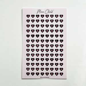 May include: A sheet of pink stickers with black heart shapes, each containing a letter of the alphabet in pink. The text "Mono Child" is at the top, and "@monochildshop" is at the bottom.