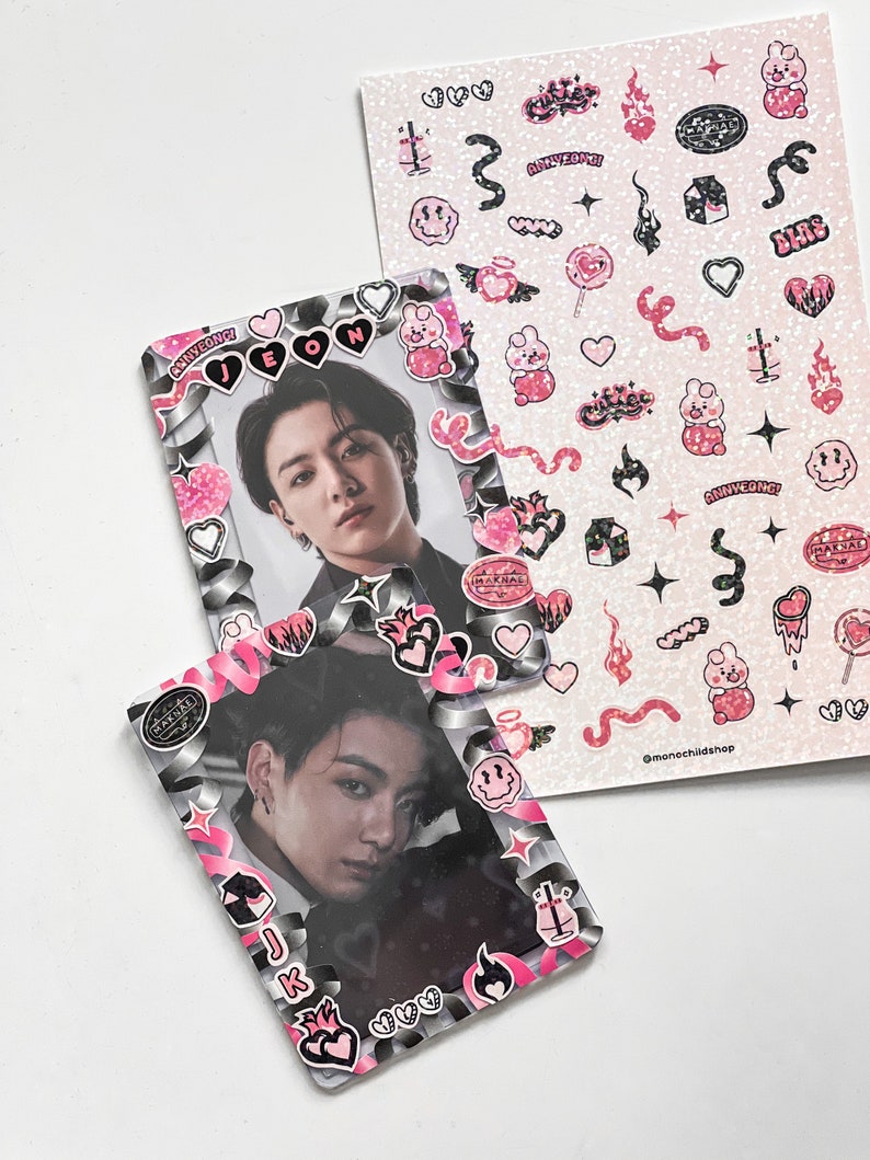 May include: Two photo card holders with a picture of a person, decorated with pink and black stickers. A sheet of stickers with various pink and black designs, including hearts, flames, and text, is also visible. The stickers have the text "MAKNAE", "ANNYEONG!", and "MAKNAE".