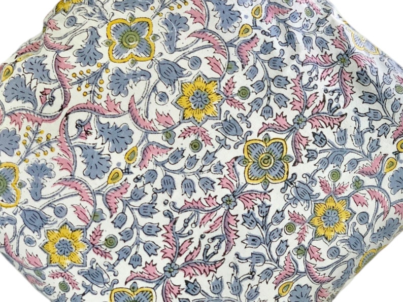 May include: White fabric with a floral pattern in shades of pink, blue, and yellow. The pattern features intricate designs of leaves, flowers, and vines.