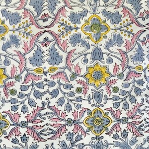 May include: A white fabric with a repeating floral pattern in shades of pink, blue, and yellow. The pattern features stylized flowers, leaves, and vines.
