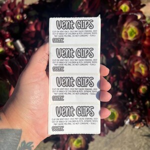 May include: A vertical strip of four white rectangular labels featuring the text Vent Clips in a bold font. Each label includes safety warnings about oil staining, keeping away from children and pets, and avoiding extreme temperatures.